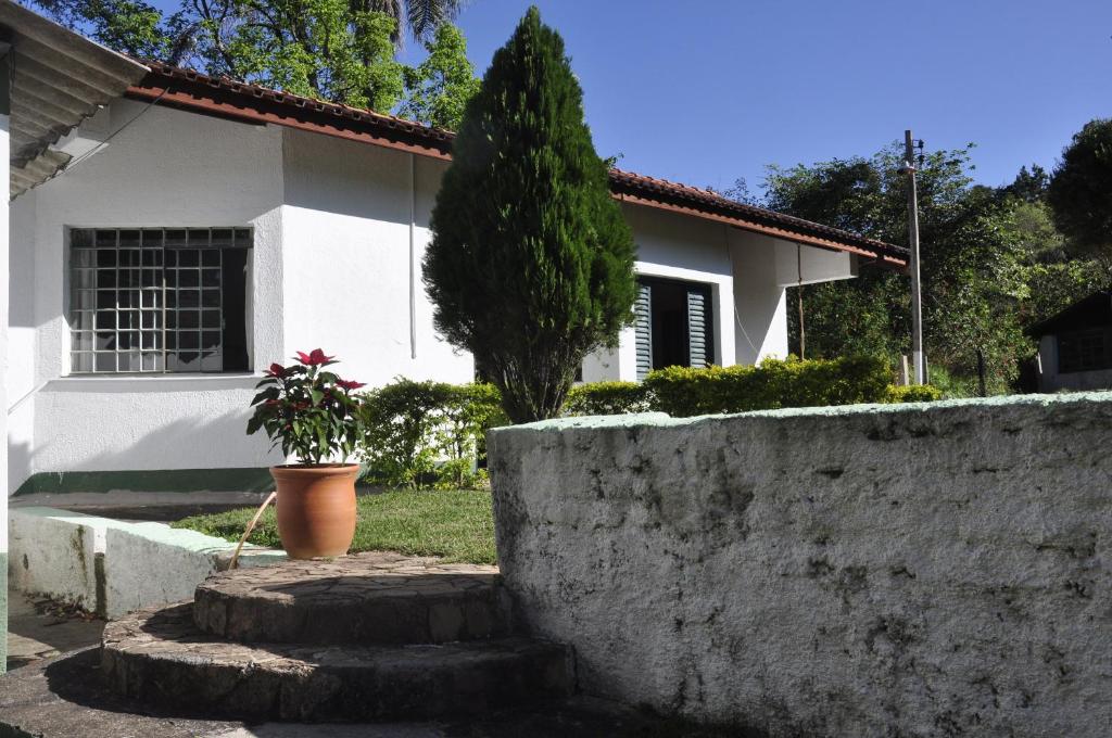 a house with a retaining wall and a plant at Chalé e Camping Daragona 2 in Águas de Lindóia