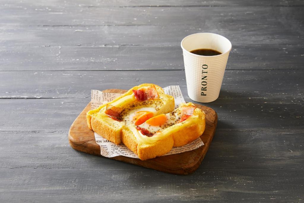 a sandwich on a cutting board next to a cup of coffee at Sotetsu Fresa Inn Tokyo-Toyocho in Tokyo