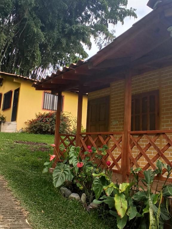 uma cerca de madeira em frente a uma casa em Alojamiento Campestre Cabañas Mirador Ingrumá Riosucio Caldas em Ruiosucio