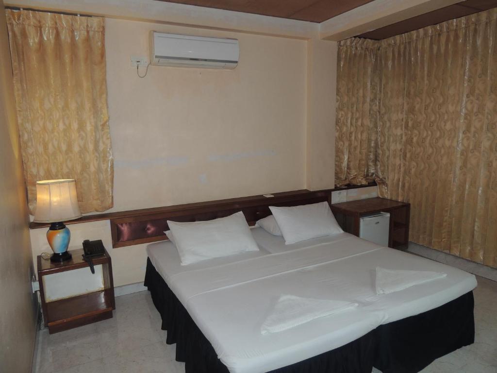 馬累的住宿－關天酒店，卧室设有一张白色大床和一扇窗户。