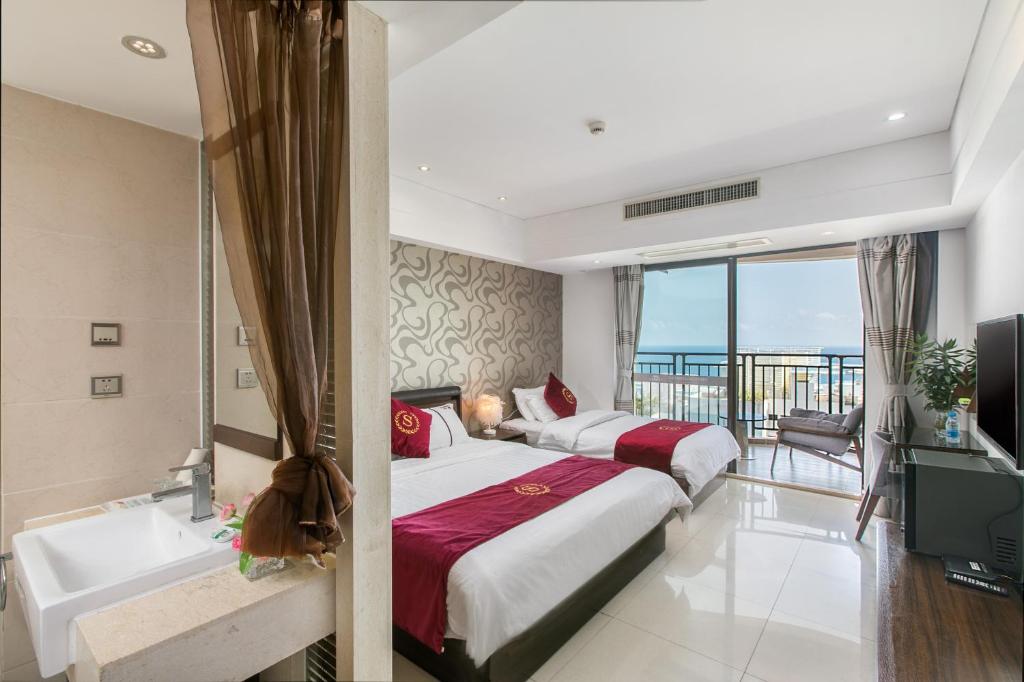 a hotel room with two beds and a tub and a bathtub at Sanya Sun and Sea Gueshouse in Sanya