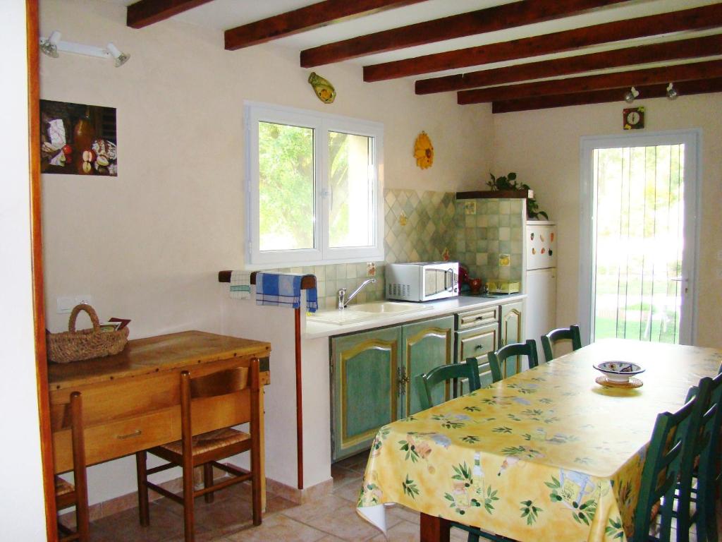 a kitchen with a table and a sink and a table and chairs at Chambres d&#39;Hôtes de Curnier in Bédoin