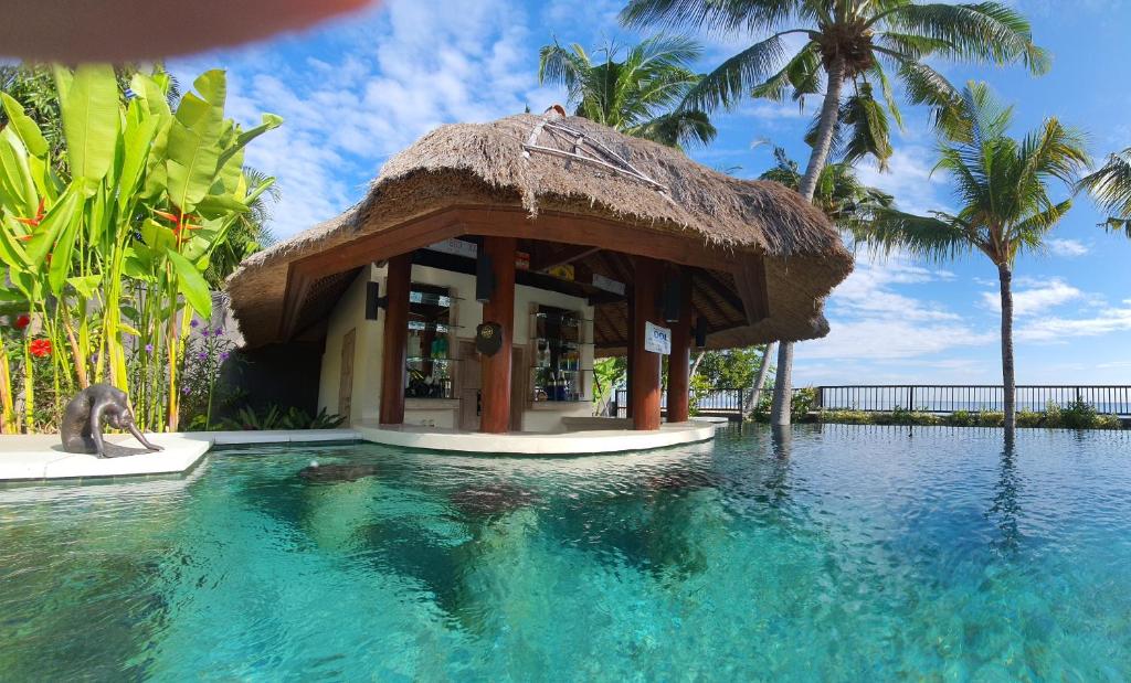 a resort with a swimming pool with a hut at InBalance Resort in Buleleng