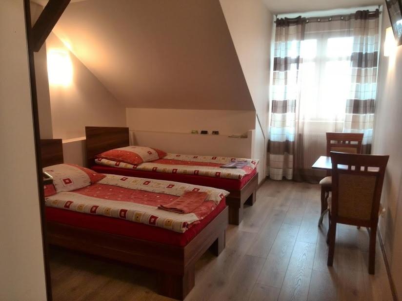 two beds in a room with a table and chairs at Noclegi Tyczyn in Tyczyn