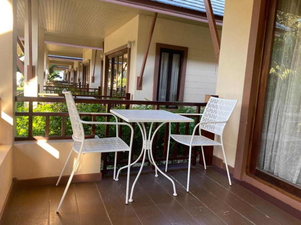 - une table et des chaises sur la terrasse couverte d'une maison dans l'établissement Chaithalay Khanom Resort, à Ban Phang Phrao