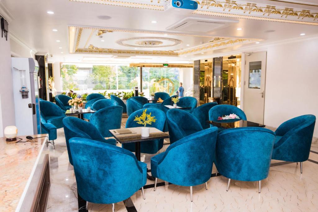 a room with blue chairs and tables and a mirror at HM Hotel& Apartment in Hai Phong
