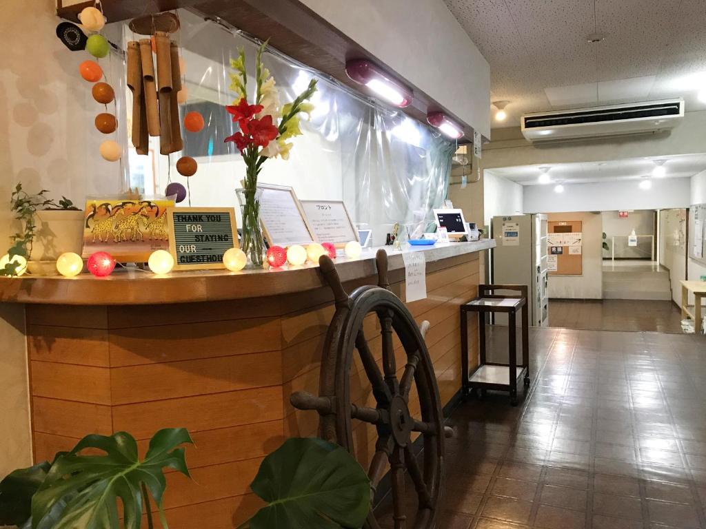 a bar in a restaurant with flowers on the counter at Shodoshima Olive Youth Hostel in Shodoshima