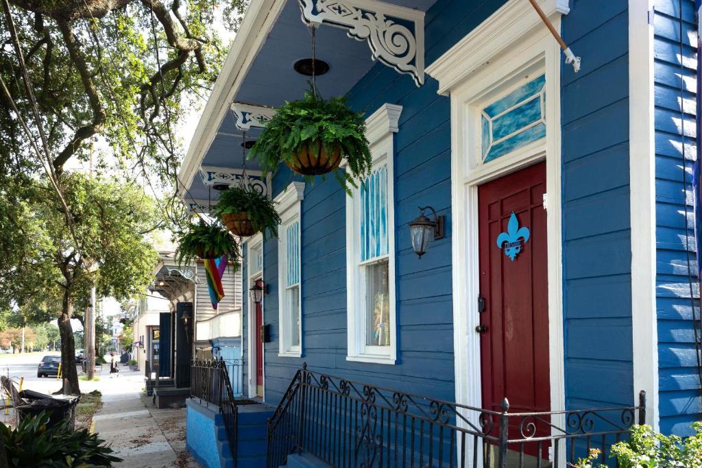a blue house with a red door on a street at Blue60 Marigny Inn in New Orleans