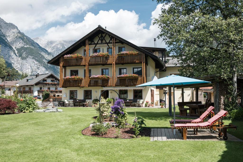 a house with a table and chairs in a yard at Landhaus Gemsenblick in Leutasch