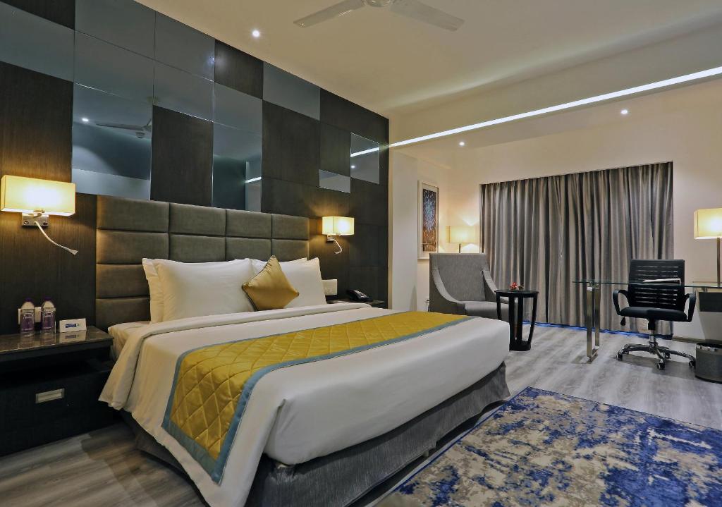 een hotelkamer met een groot bed en een bureau bij Best Western Plus Tejvivaan in Visakhapatnam