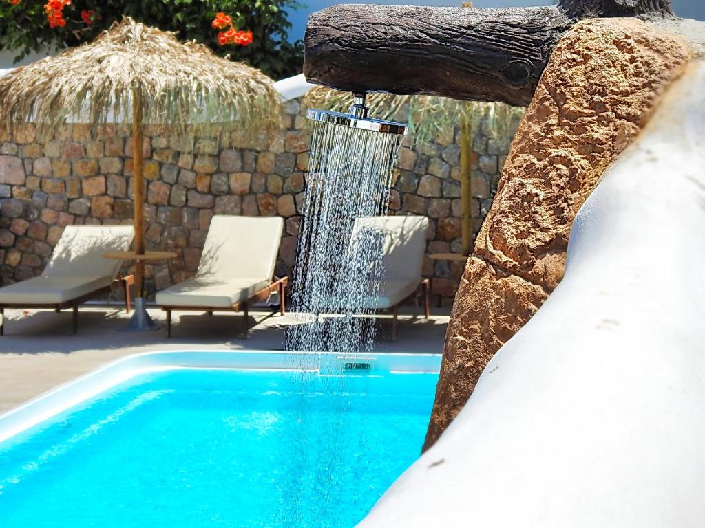 a swimming pool with a water fall at Avraki in Kamari