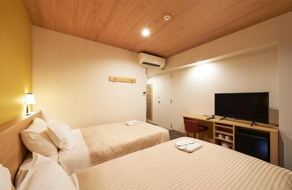 Postel nebo postele na pokoji v ubytování Sotetsu Fresa Inn Tokyo Tamachi