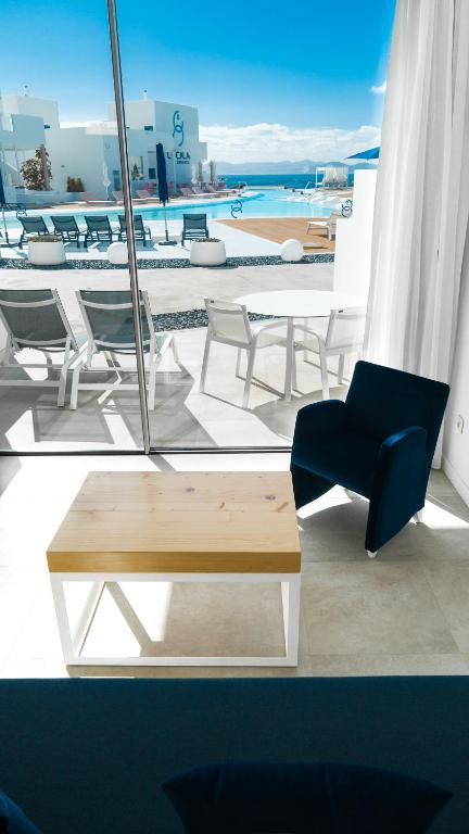 a table and chairs on a balcony with a view of the ocean at CalaLanzarote Suites Hotel - Adults Only in Playa Blanca