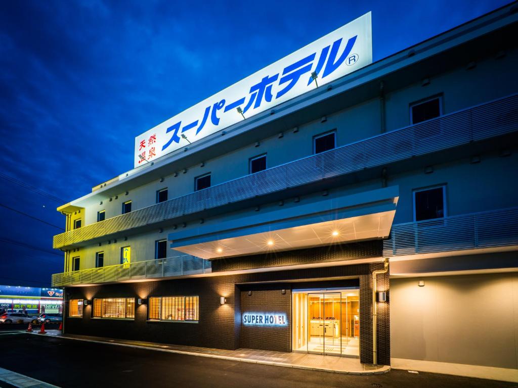a building with a sign on the top of it at Super Hotel Fujinomiya in Fujinomiya