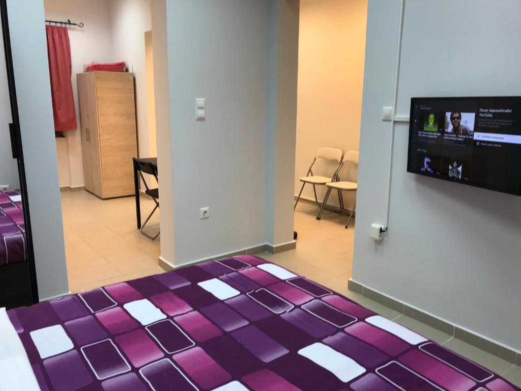 een kamer met een paars bed en een flatscreen-tv bij Athens Spirit 49 katechaki apartment in Athene