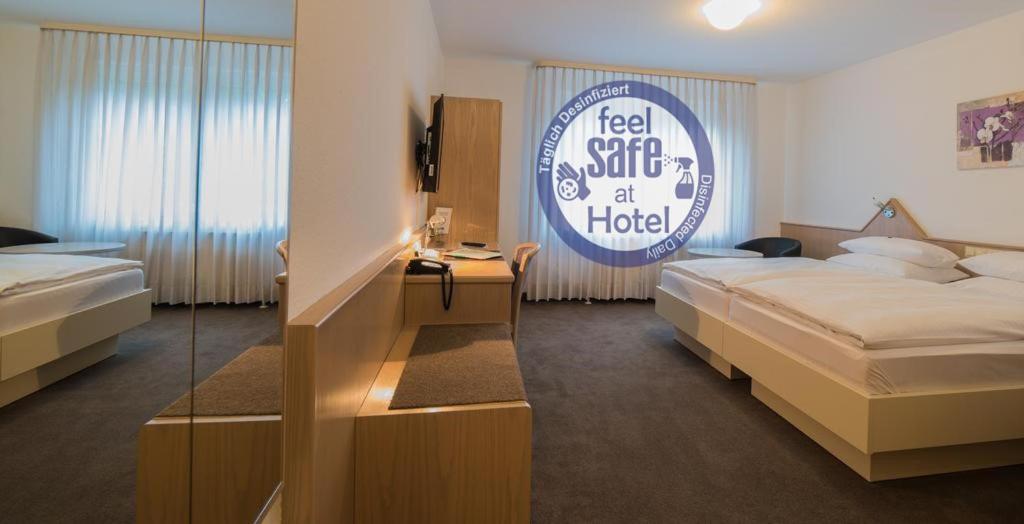 a hotel room with two beds and a sign at Hotel am Wasen in Freiberg am Neckar