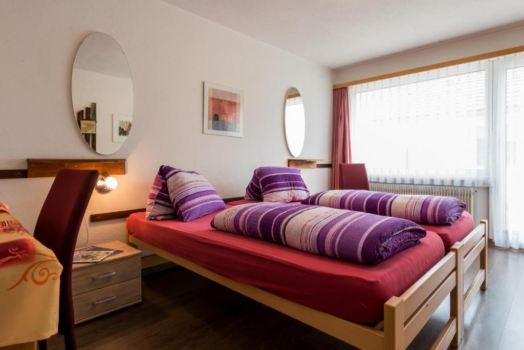 una cama con almohadas en una habitación en Hotel du Pont, en Gampel
