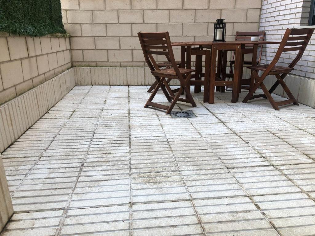 a patio with a wooden table and two chairs at Palacio de Los Luna in Zaragoza