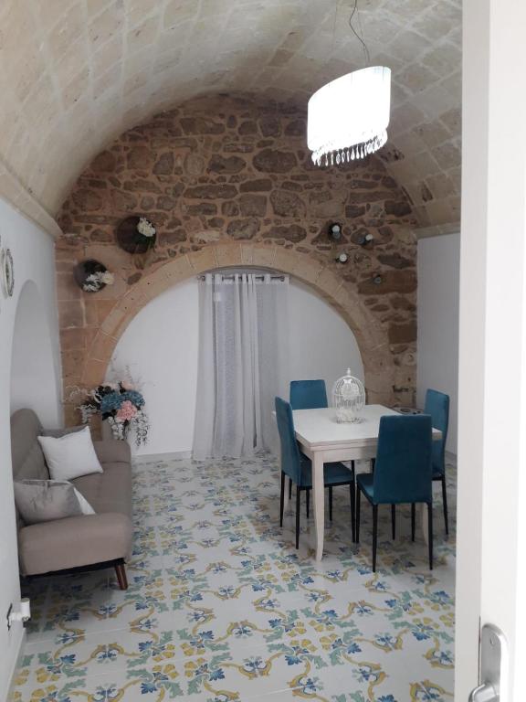 ein Esszimmer mit einem Tisch und blauen Stühlen in der Unterkunft casa vacanze Vico Verona 7 in Oria