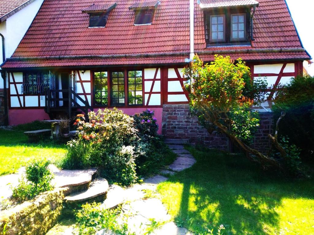 una pequeña casa con techo rojo en Ferienhaus Marré - mit Grill, Feuerstelle und Gartensauna en Waldbrunn