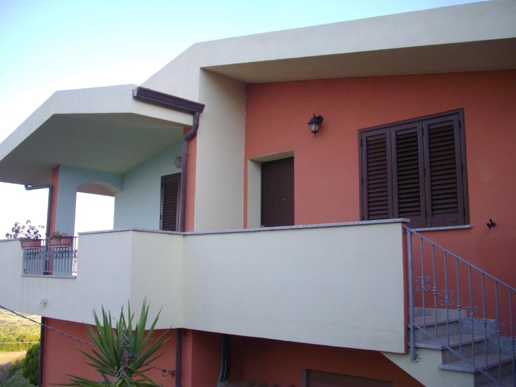 a house with a balcony and a staircase at Appartamento Sofia - Nord Sardegna - Badesi in Badesi