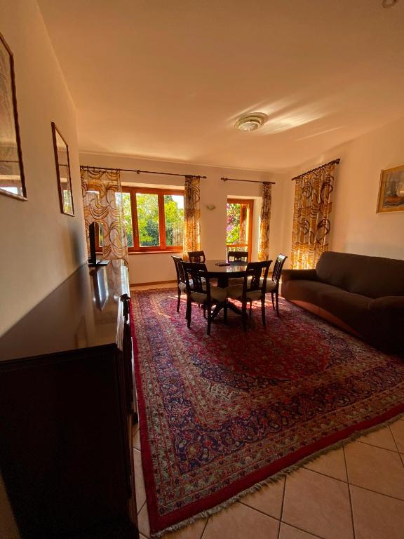 a living room with a table and chairs on a rug at casa alla Valle in Salò