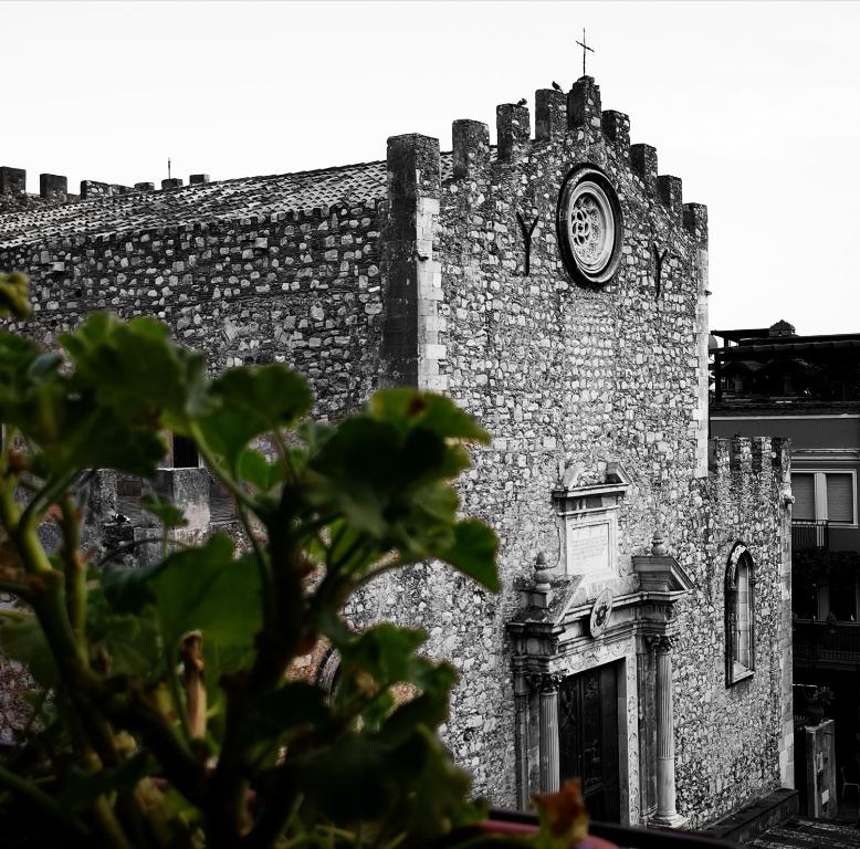 an old brick building with a clock on it at Casa Viola - Al Centro in Taormina