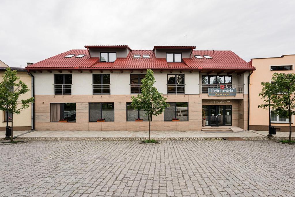 um edifício com uma árvore em frente em Hotel Menhard em Vrbov