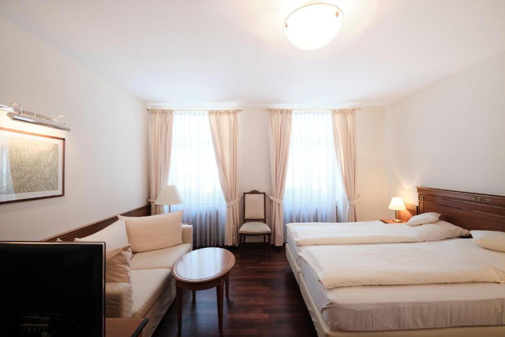 a hotel room with two beds and a couch at Hotel Weisser Bock in Heidelberg