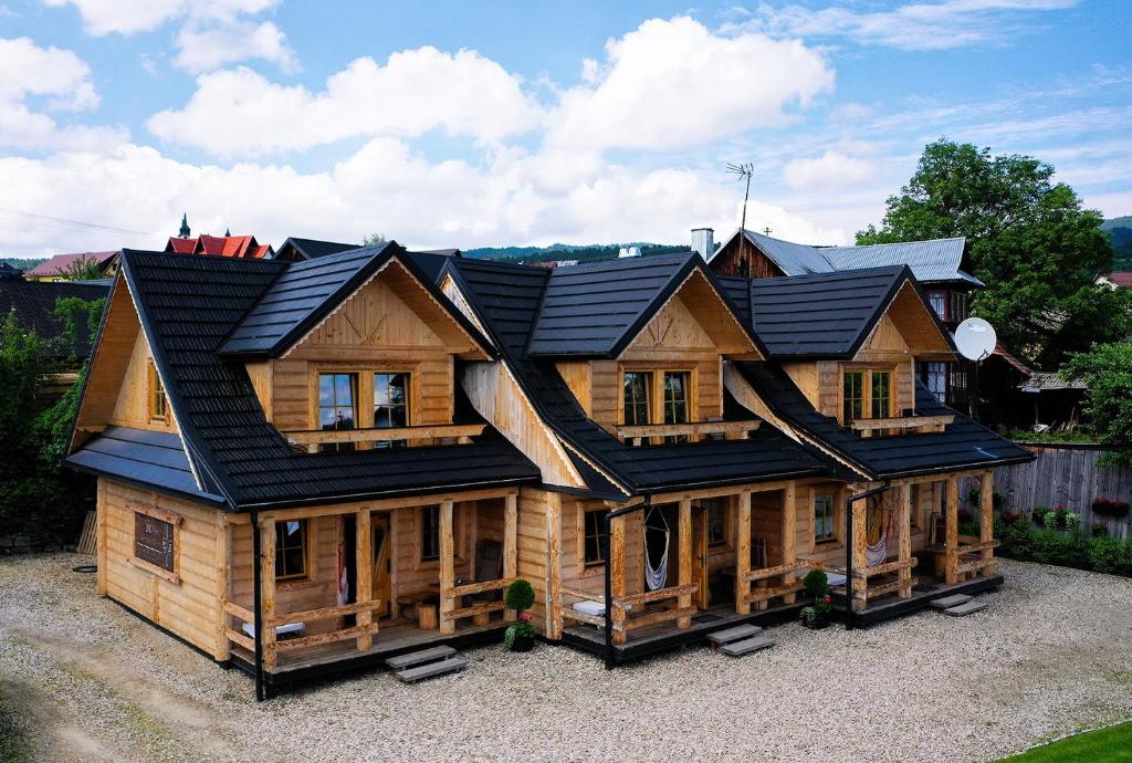 a large wooden house with a black roof at Góralskie domki - Kluszkowce in Kluszkowce