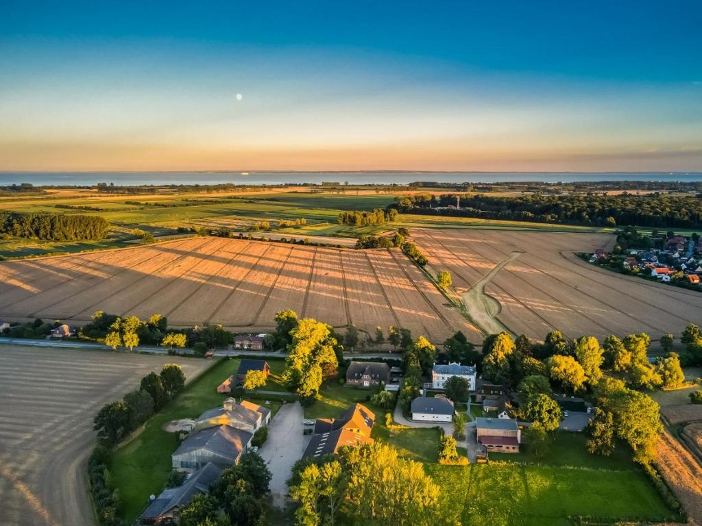 une vue aérienne sur une ferme avec un grand champ dans l'établissement Kavaliershaus Henriettenhof, à Grömitz