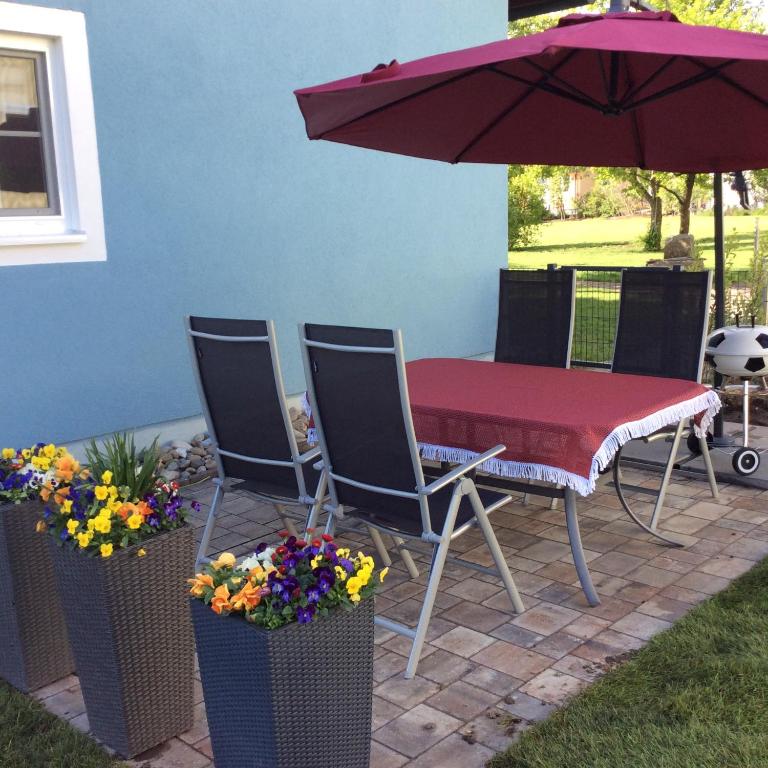 a patio with a table and chairs and an umbrella at Kaiser FeWo in Neusitz