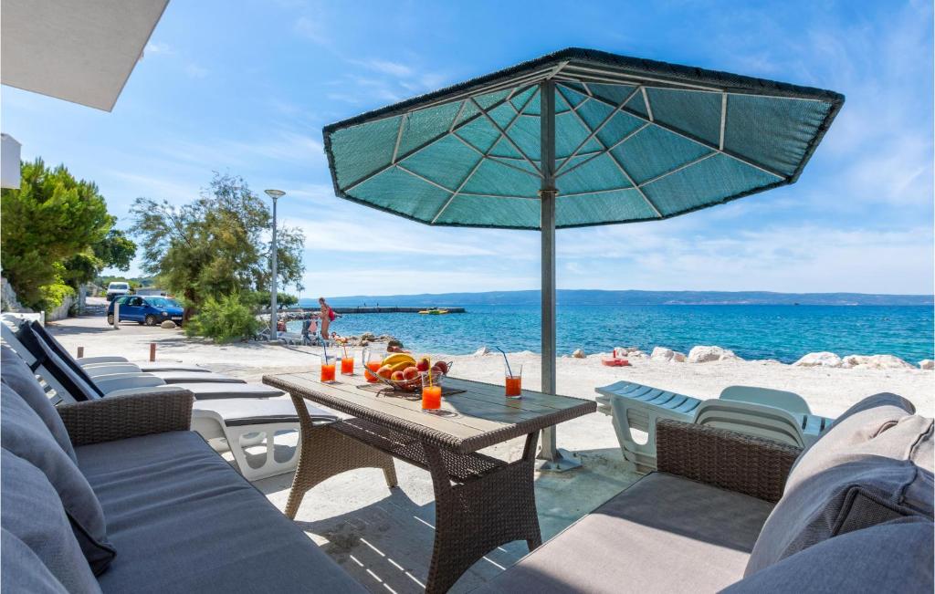 a table with an umbrella on a beach at Lovely Apartment In Podstrana With Wifi in Sveti Martin