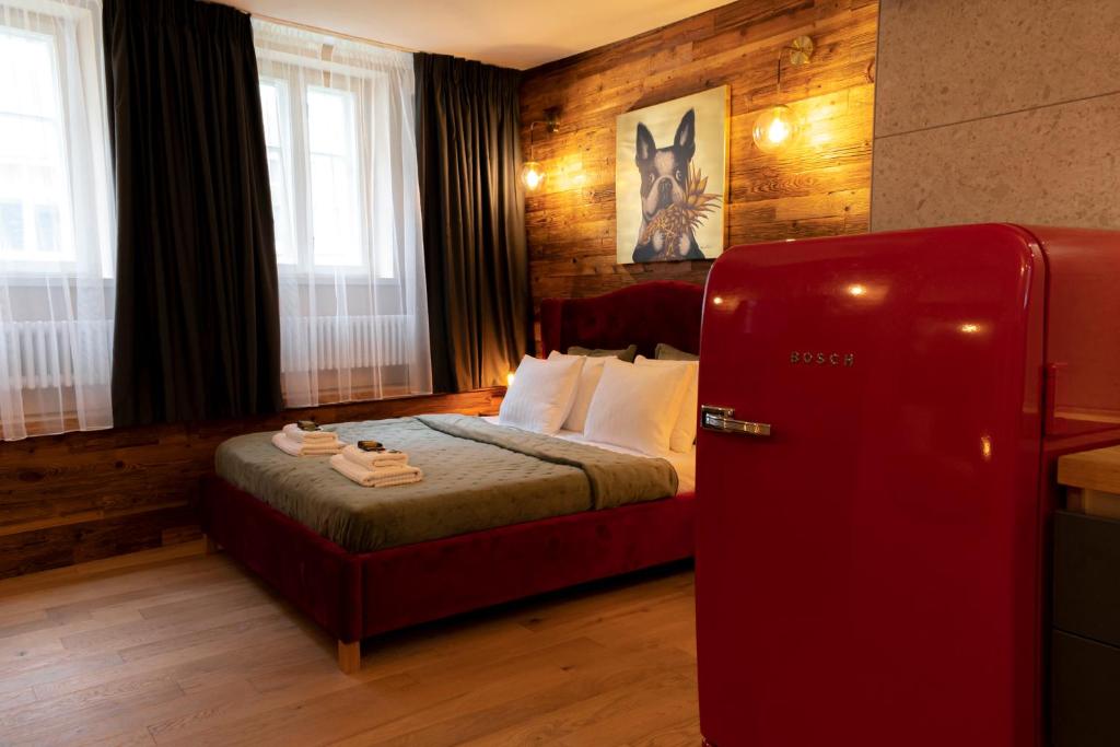 a bedroom with a red refrigerator next to a bed at Boutique Apartment Venezia Duo in Kuldīga