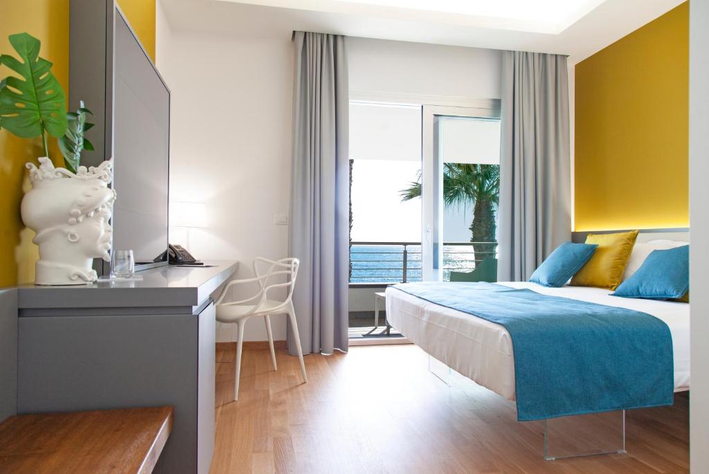 a bedroom with a bed and a desk and a window at Santantonioresort in Riposto