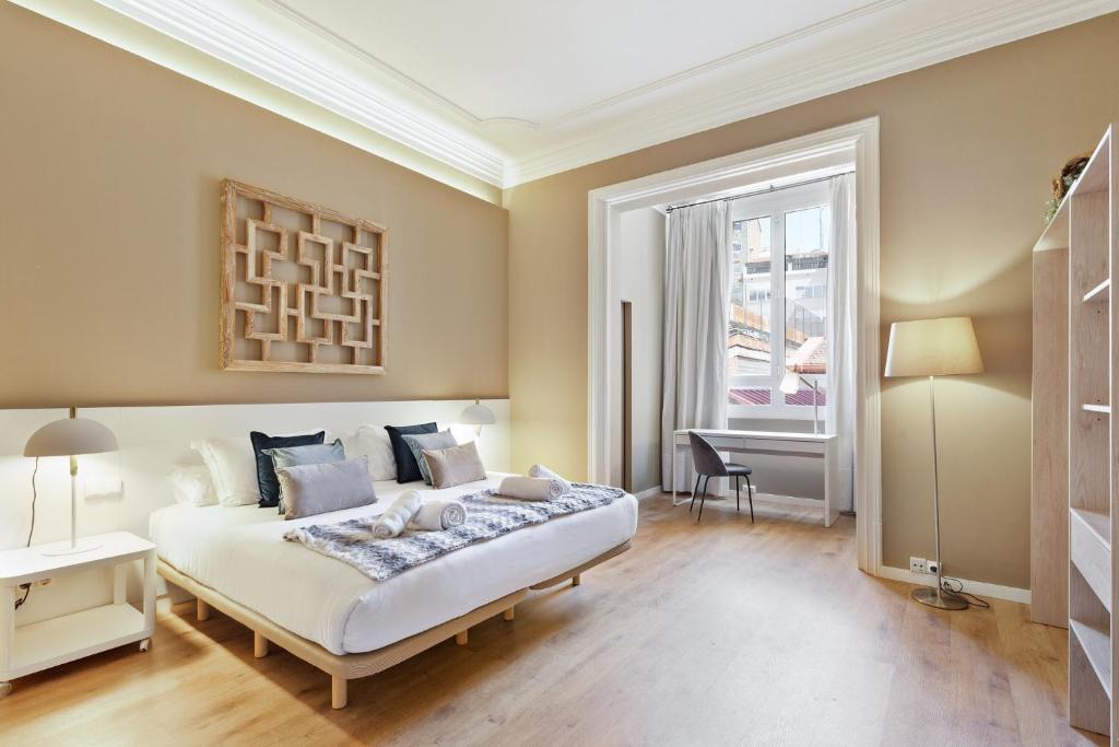 a bedroom with a bed and a desk and a window at Ola Living Diagonal Apartments in Barcelona