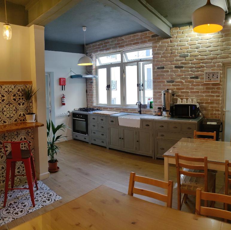 eine Küche mit einem Tisch und einer Ziegelwand in der Unterkunft Walter's B&B in Gżira