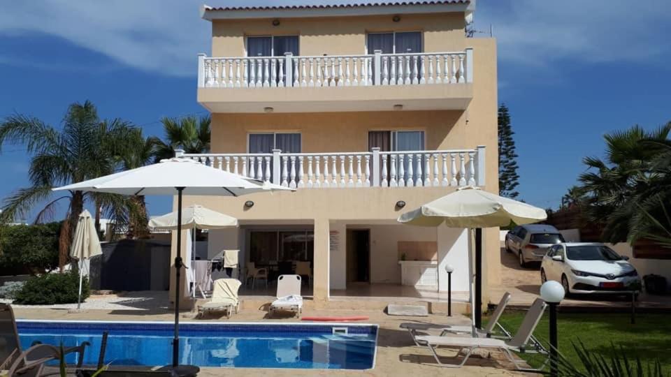 a villa with a swimming pool and a house at Diamond Villas in Paphos City