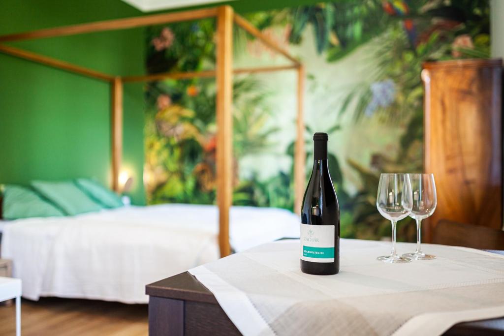 a bottle of wine sitting on a table with two glasses at ZACHÁR Apartman in Sopron