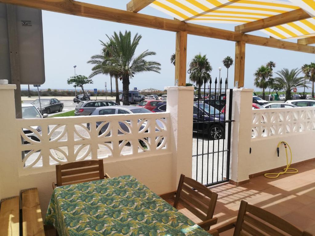 patio ze stołem i krzesłami oraz parking w obiekcie Miramar Conil w mieście Conil de la Frontera