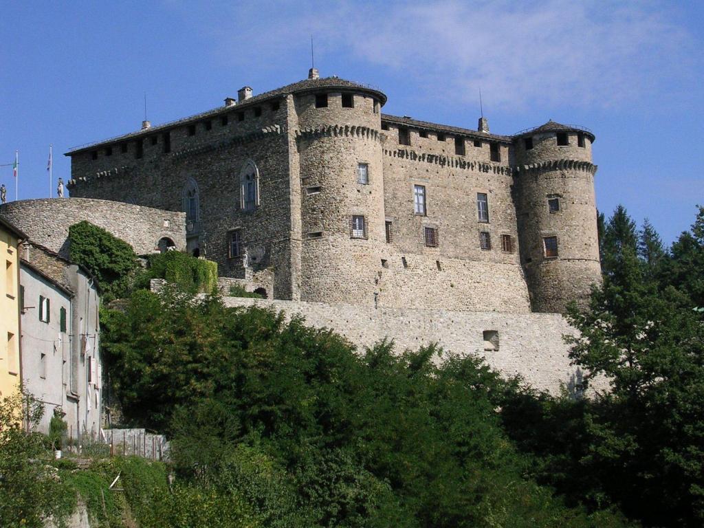 a large castle sitting on top of a hill at Castello Di Compiano Hotel Relais Museum in Compiano