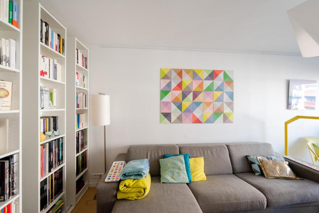 ein Wohnzimmer mit einem Sofa und Bücherregalen in der Unterkunft Beautiful Apt With Balcony Parc Montsouris Rer B in Paris