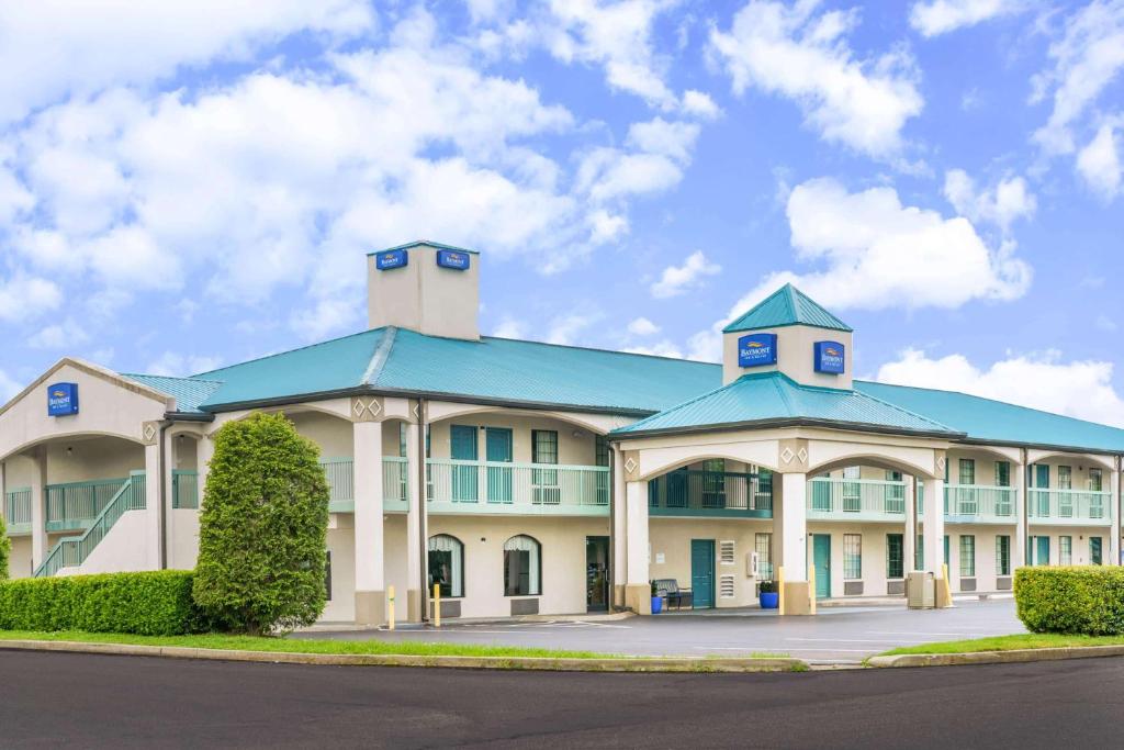 a large white building with a blue roof at Baymont by Wyndham Gallatin in Gallatin