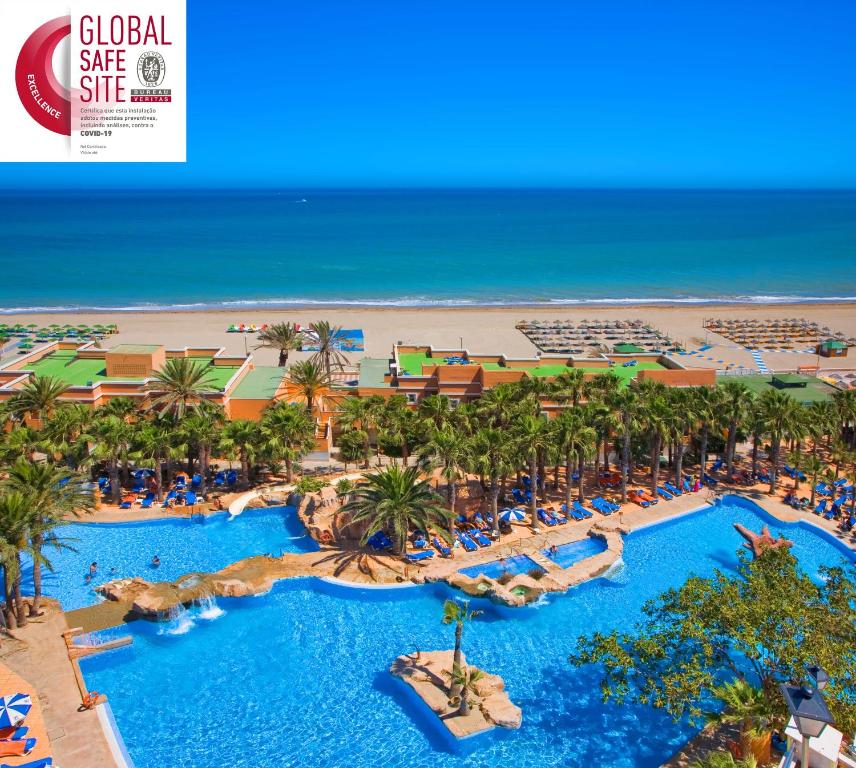 
a beach filled with palm trees and palm trees at Playacapricho Hotel in Roquetas de Mar
