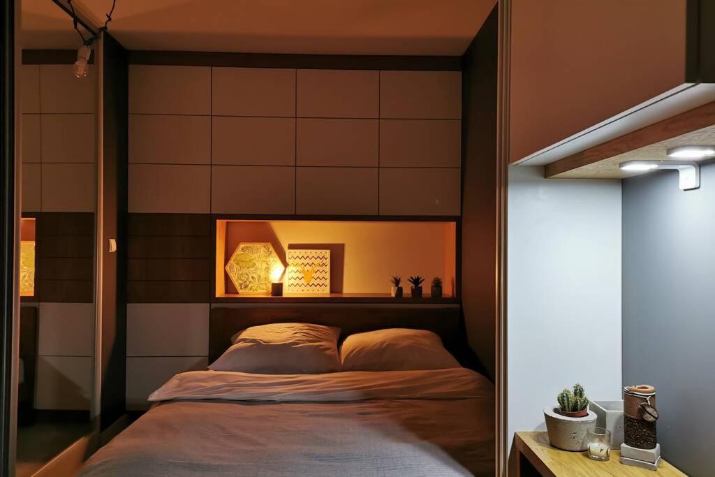 a bedroom with a bed with a wooden headboard at Przytulne nowoczesne studio z tarasem nad Dunajcem in Nowy Targ