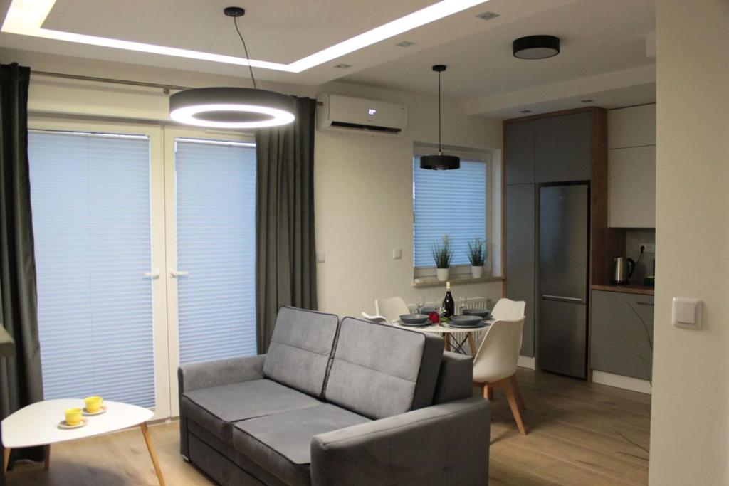 un soggiorno con divano e tavolo di Apartament Wspólna19 (Centrum, garaż podziemny, klimatyzacja ) a Kielce