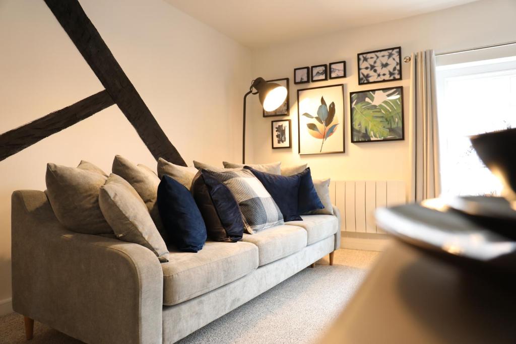 uma sala de estar com um sofá com almofadas em Blueberry View-Wyndale-2BR Boutique Worcester em Worcester