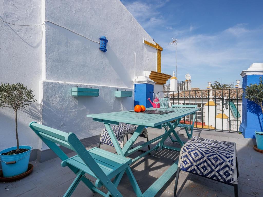 een blauwe tafel en stoelen op een balkon bij San esteban bajo in Sevilla