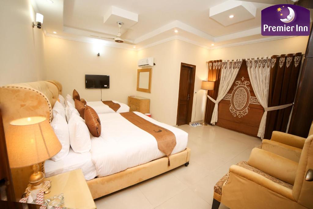 een hotelkamer met een bed en een bank bij Premier Inn Grand Gulberg Lahore in Lahore