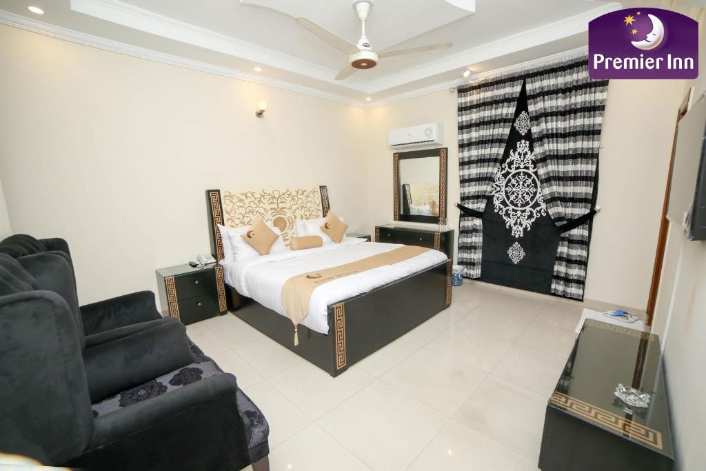 Premier Inn Grand Gulberg Lahore في لاهور: غرفة نوم بسرير وكرسي وأريكة